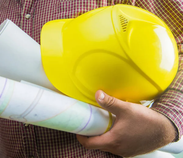 Architekt Hält Der Hand Blaupausen Und Gelben Kunststoffhelm Strukturierter Wand — Stockfoto