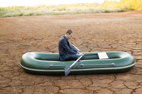 sad funny Business man on cracked soil hot land desert.  symbol of crisis