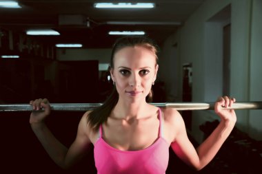 metal barbell ile çalışma ciddi atlet kız portresi. spor giyim güzel kadın spor salonu içinde eğitiyor. 