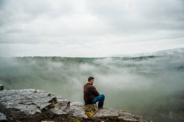 Dağ tepe üzerinde bir dinlenme alarak uzun yürüyüşe çıkan kimse adam. 