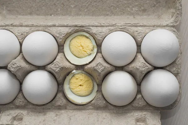 Eggs in paper tray. one is boiled. view from above. Organic eggs in a paper tray