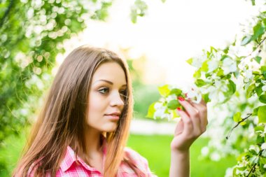 sıcak yaz güneşli bir günde elma ağacının yanında duran kadın 