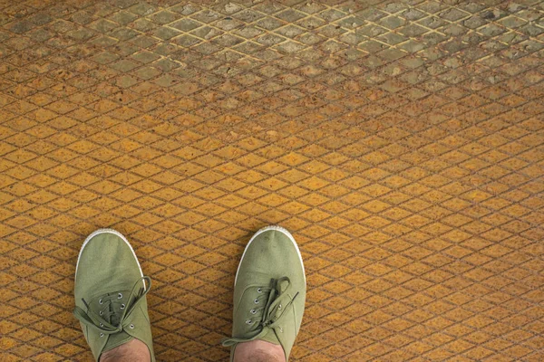 男子在鞋上生锈的金属地板背景 用于题词的空白复制空间 — 图库照片