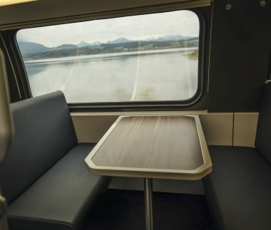 Penceresinde - seyahat arka plan tren ve Alp Dağları'nın iç. boş ahşap masa ve sandalye
