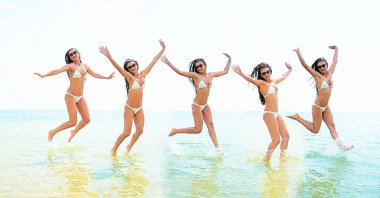 gün batımında okyanusa atlayan genç bir grup insan.