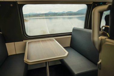 Penceresinde - seyahat arka plan tren ve Alp Dağları'nın iç. boş ahşap masa ve sandalye