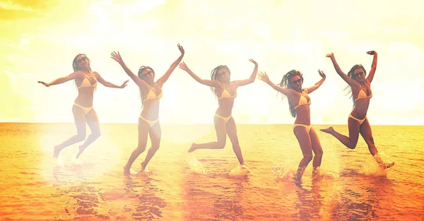 Młoda Grupa Ludzi Skoki Oceanie Zachodzie Słońca — Zdjęcie stockowe