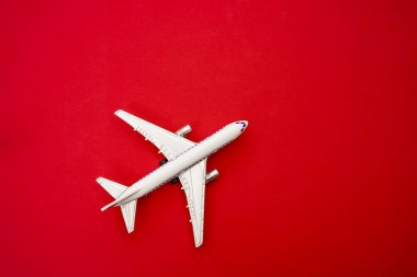 metal oyuncak - kırmızı kağıt arka plan uçakta. modern uçak izole kırmızı zemin üzerinde. 