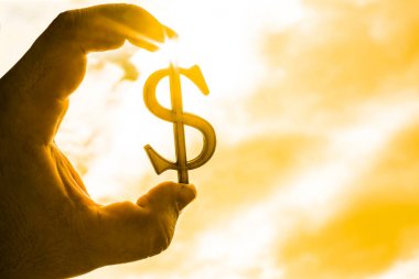 Dolar işareti silüeti vasıl günbatımı geçmiş tutan el