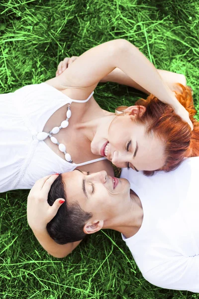 年轻的情侣躺在一起 头上的绿草在夏天 家庭野餐 — 图库照片