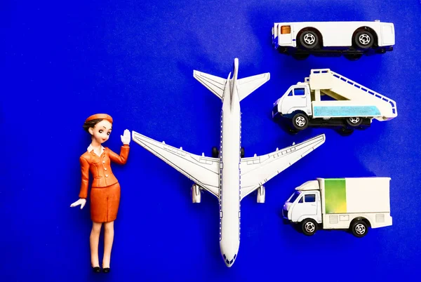 plane, stewardess, truck with baggage and aircraft gangway on blue paper background