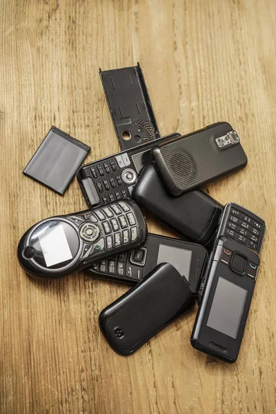 Gebrauchte Alte Mobiltelefone Mit Akkus Auf Holztischhintergrund — Stockfoto