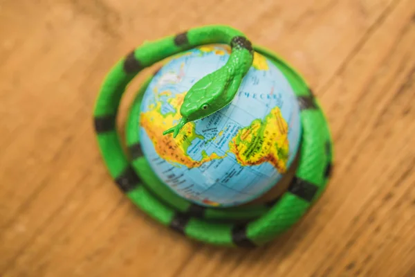 Zielony Czarny Wąż Wokół Planety Ziemi Symbolizujących Niebezpieczeństwo — Zdjęcie stockowe