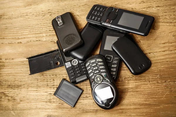 Gebrauchte Alte Mobiltelefone Mit Akkus Auf Holztischhintergrund — Stockfoto