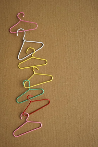 many colorful hangers  on brown craft texture background