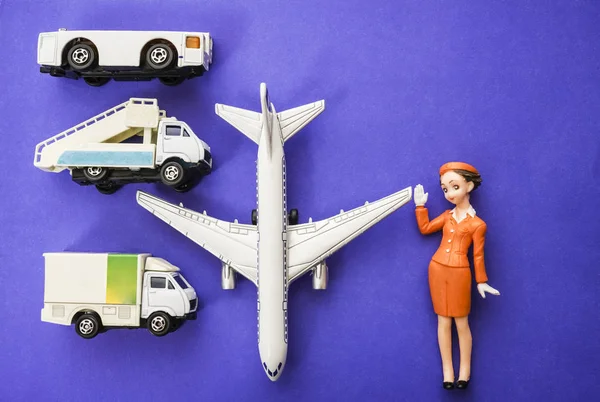 plane, stewardess, truck with baggage and aircraft gangway on blue paper background