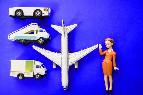 plane, stewardess, truck with baggage and aircraft gangway on blue paper background
