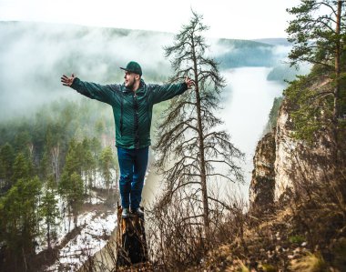 güdük bir orman nehir karşı çevresinde yeşil bir ceket genç adam