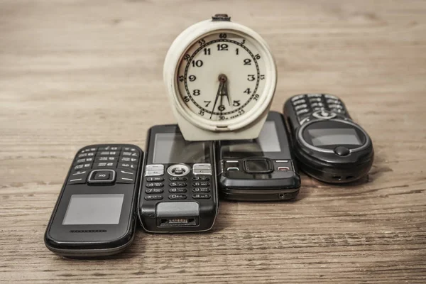 Wecker Und Alte Mobiltelefone Holztisch Hintergrund — Stockfoto