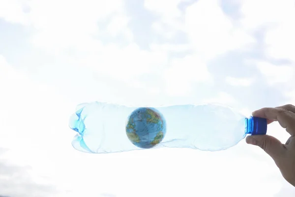 Męska Ręka Trzymająca Plastikową Butelkę Niebieskim Globusem Tle Nieba Koncepcja — Zdjęcie stockowe