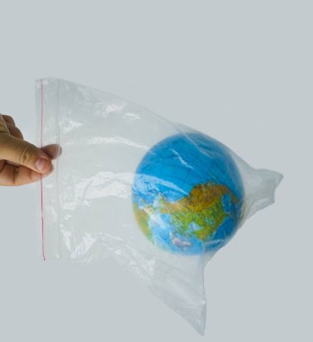 Beyaz arka planda Dünya küresi ile plastik poşet tutan bir adam var..
