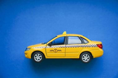 Moskova, Rusya - 23 Ekim 2019: Sarı taksi arabası Lada Granta mavi arka planda. Taksi servisi konsepti.