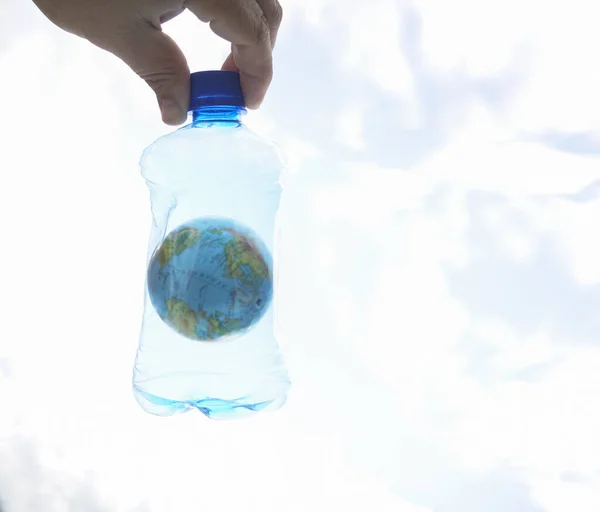 Męska Ręka Trzymająca Plastikową Butelkę Niebieskim Globusem Tle Nieba Koncepcja — Zdjęcie stockowe