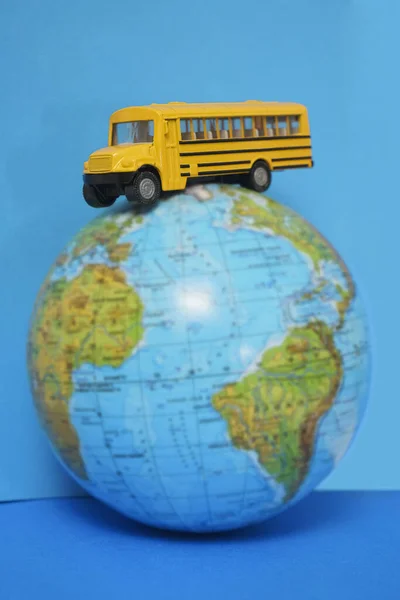 Żółty Autobus Szkolny Plastik Model Zabawki Metalowej Kuli Ziemskiej Izolowane — Zdjęcie stockowe
