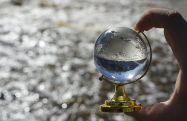 Temiz cam top - dünya haritası - Bokeh nehrinin arkasında. şeffaf cam. 