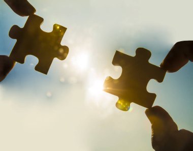 Yapboz parçaları olan eller. takım çalışması konsepti