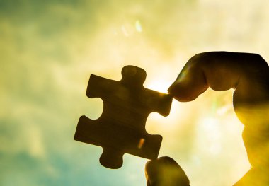 Gün batımı arkaplanı olan çift yapboz parçasını bağlamaya çalışıyorum.