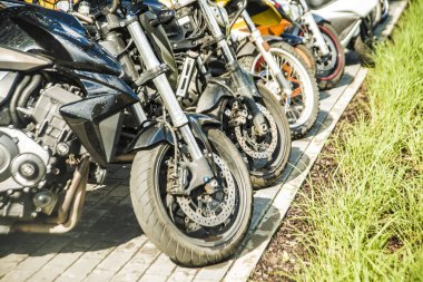 Polonya, Varşova - 27 Mayıs 2017: Motosikletler üst üste. Motosikletler yeşil çimlerin yanında bir sırada duruyor.. 