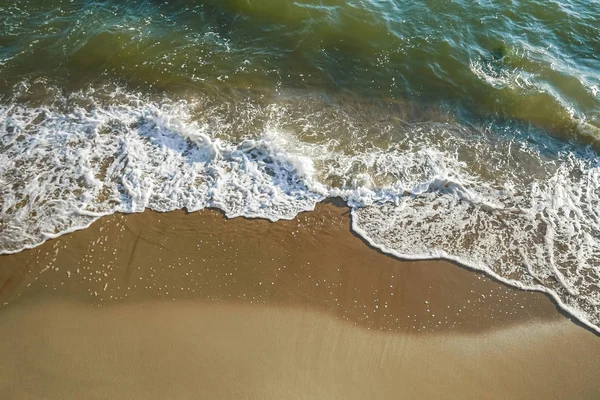 Above vertical view of blue ocean waves and yellow sandy beach - summer holiday vacation concept - travel and scenic place - energy nature outdoors with nobody there