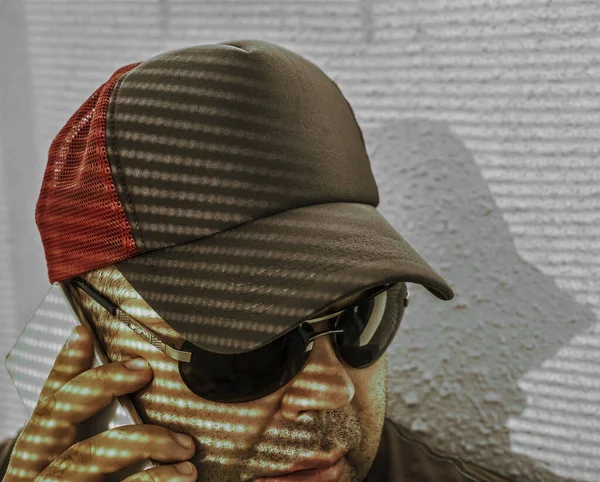 Portret Brodatego Mężczyzny Czapce Okularach Przeciwsłonecznych Pomocą Smartfona Światło Cień — Zdjęcie stockowe