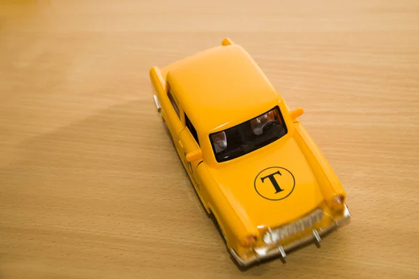 Gelbes Taxiauto Spielzeugmodell Isoliert Auf Holzhintergrund — Stockfoto