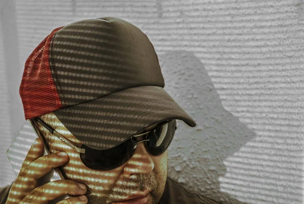스마트폰을 사용하여 모자를 선글라스를 남자의 초상화 얼굴의 그림자 — 스톡 사진
