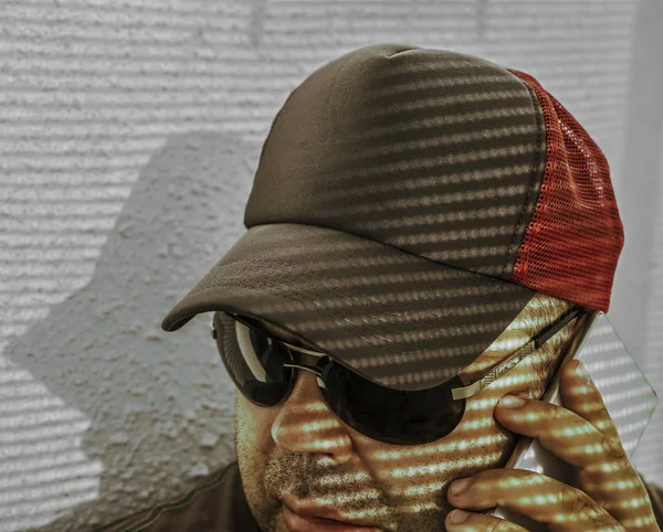 Portret Brodatego Mężczyzny Czapce Okularach Przeciwsłonecznych Pomocą Smartfona Światło Cień — Zdjęcie stockowe