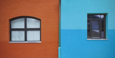 two 2  Windows on the orange and blue wall