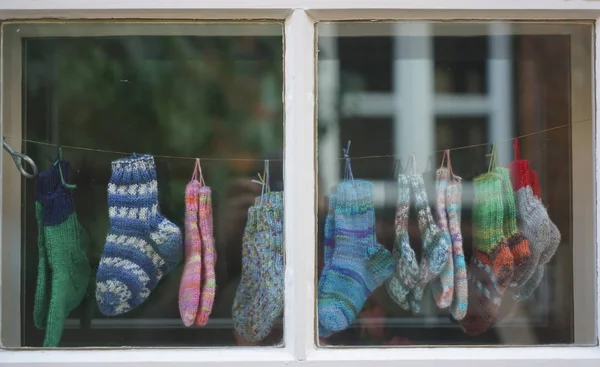 Baby Gebreide Sokken Opknoping Een Winkel Raamkozijn Achtergrond — Stockfoto