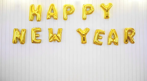 Words - happy new year in English alphabet from  balloons on a white wall background. holidays and education idea. 2020 happy new year - inscription.