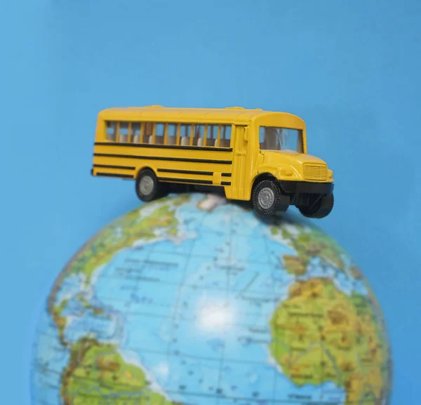 Żółty Autobus Szkolny Plastik Model Zabawki Metalowej Kuli Ziemskiej Izolowane — Zdjęcie stockowe