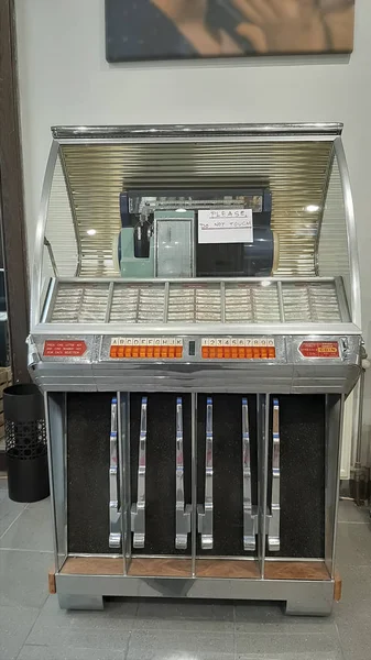 Retro music box, bar customer choosing favorite melody, entertainment nostalgia. vintage jukebox in the night cafe.