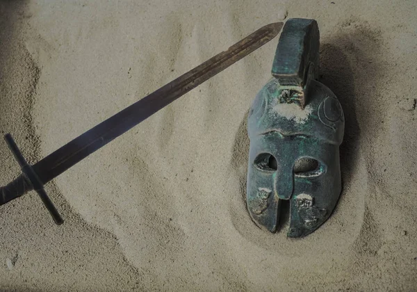 helmet of ancient warriors on sand background. Roman or ancient  greece Legionar. empty copy space for inscription.