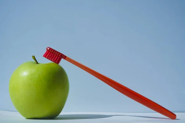 Pomme Verte Avec Brosse Dents Rouge Isolée Sur Fond Bleu — Photo