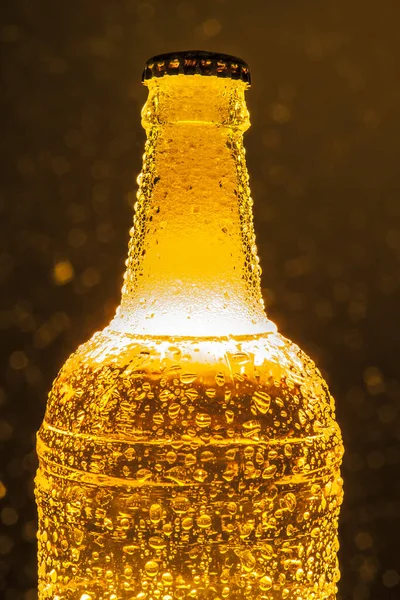 white Beer with foam - Lager beer in transparent  bottle. Isolated on yellow bokeh background