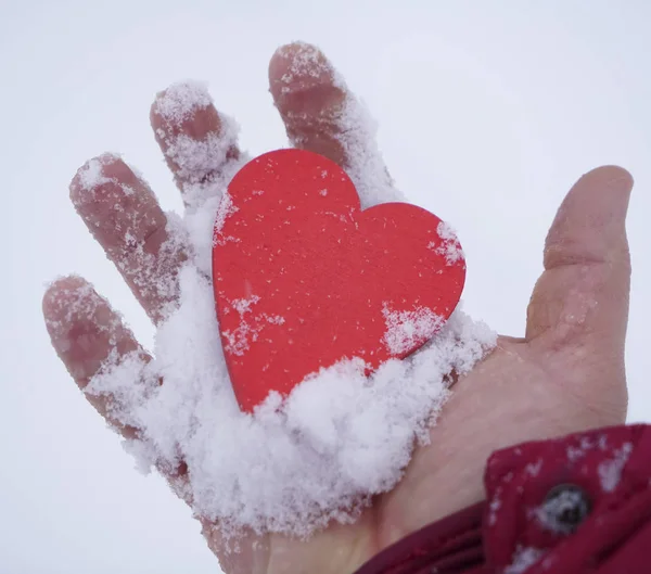 Человек Держащий Руке Деревянное Красное Сердце Фоне Снежных Заносов — стоковое фото