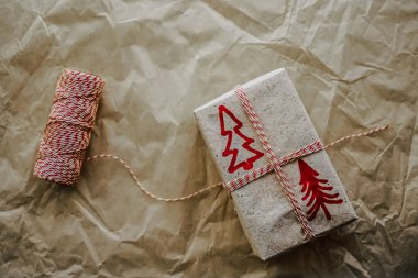 Noel teması. Noel ve 2020 yılbaşı için el yapımı hediye paketi. Noel hediyesini el işi kâğıdı ve iplikle masanın üzerinde paketliyorum. Şık yeni yıl hediye paketleme konsepti