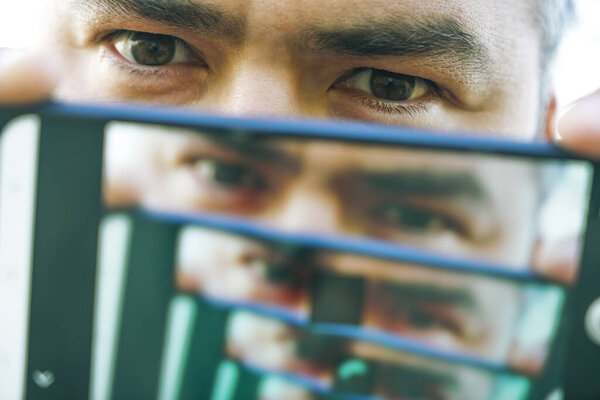 умножение эффекта между двумя зеркальными поверхностями. переосмысление мужского лица в перспективе. изображение на экране мобильного телефона. Мужской портрет
.