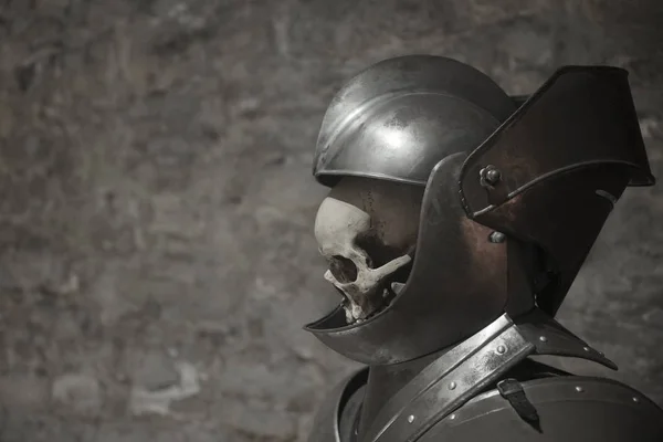 Людський череп у лицарському шоломі на сірому фоні — стокове фото