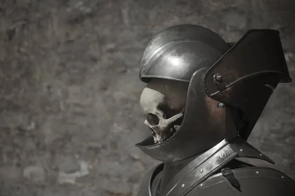 Human Skull in a knight helmet on a gray background — Stock Photo, Image